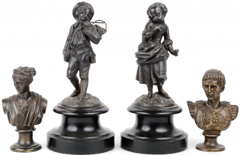 Een lot van twee paar beeldjes van zamak, bestaande uit een jongen en meisje op houten sokkel en twee romeinse bustes.