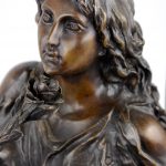 “Vrouw met roos”. Een classicistische bronzen groep op arduinen voetstuk. Gesigneerd en genummerd 3/12.