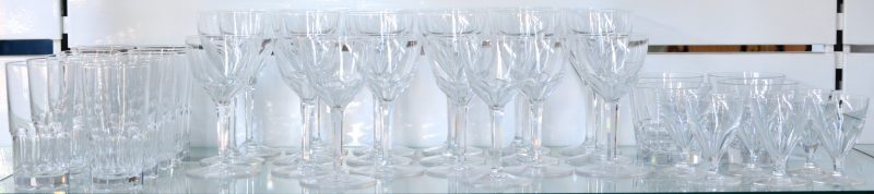 Een glasservies van kleurloos kristal, bestaande uit twaalf rodewijnglazen, acht wittewijnglazen, zes borrelglaasjes, tien longdrinks en vier whiskyglazen.