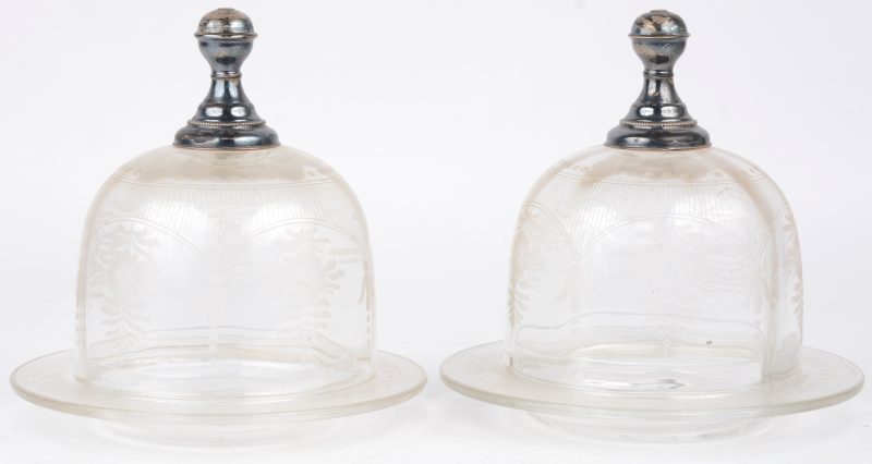 Een paar glazen botervloten met een gegraveerd bloemendecor en met vermoedelijk zilveren handvatten. Omstreeks 1900.