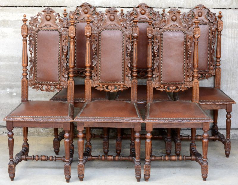 Een serie van zes gesculpteerde stoelen in Henri II-stijl met gecanneleerde stijlen en poten en versierd met bladeren.
