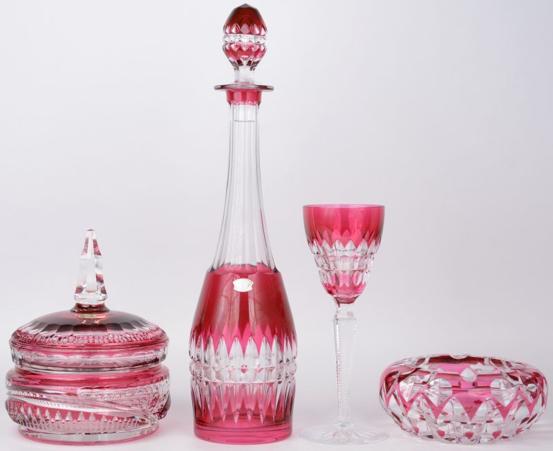 Een bonbonnière, een asbak, een glas en een karaf van geslepen kleurloos en roze kristal. Allen gemerkt, de bonbonnière genummerd.