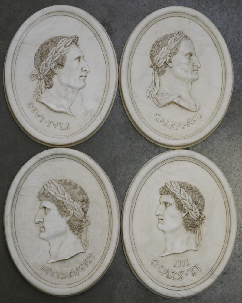 Een reeks van vier ovale plaquettes van composiet met beeltenissen van Romeinse keizers in reliëf.