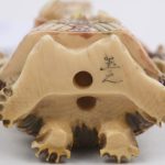 “Godheid”. Een netsuké van ivoor. Japans werk, begin XXste eeuw. Onderaan gemerkt.