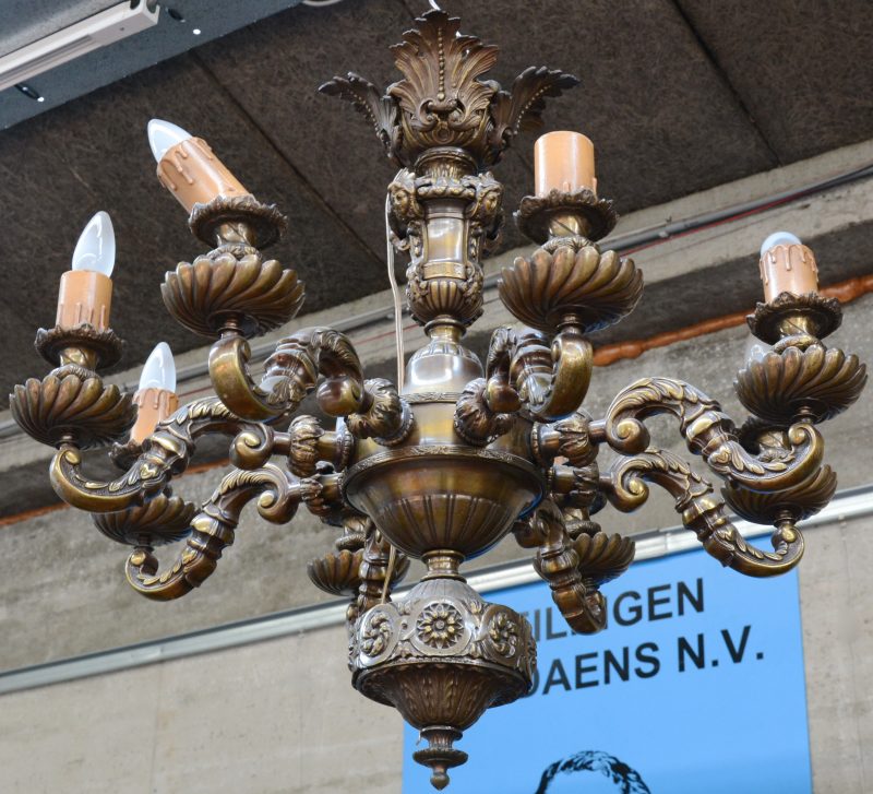 Een bronzen luchter in barokke stijl met acht lichtpunten.