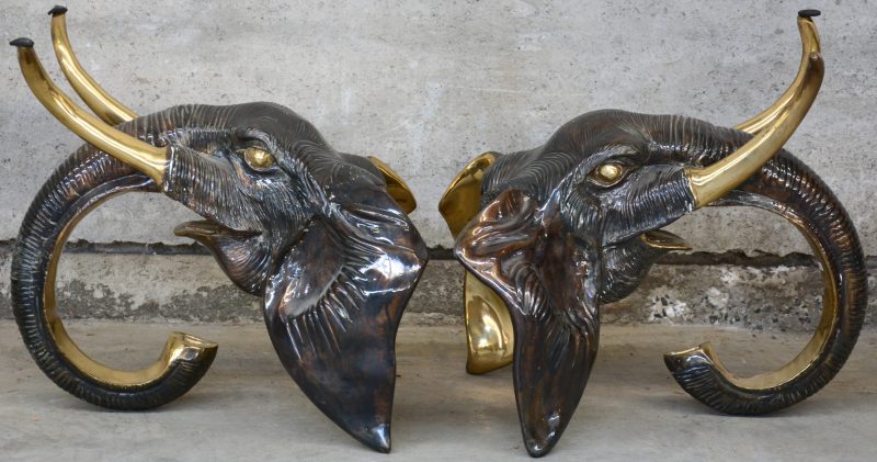 Een paar bronzen olifantenkoppen, ooit als voeten van een salontafel met glazen blad.