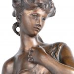 “Jonge vrouw bij een bron”. Een beeld van bruingepatineerd brons op marmeren voetstuk. Naar een werk van Moreau.