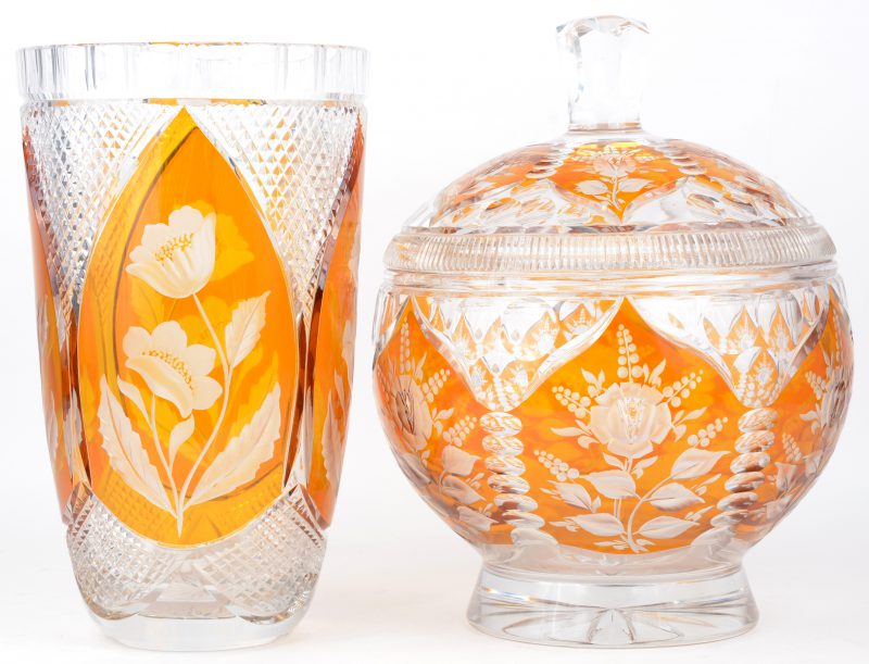 Een punchbowl en een grote vaas van geel en kleurloos kristal, versierd met een geslepen decor van bloemen. Gemerkt ‘Julia”. Punchlepel ontbreekt.
