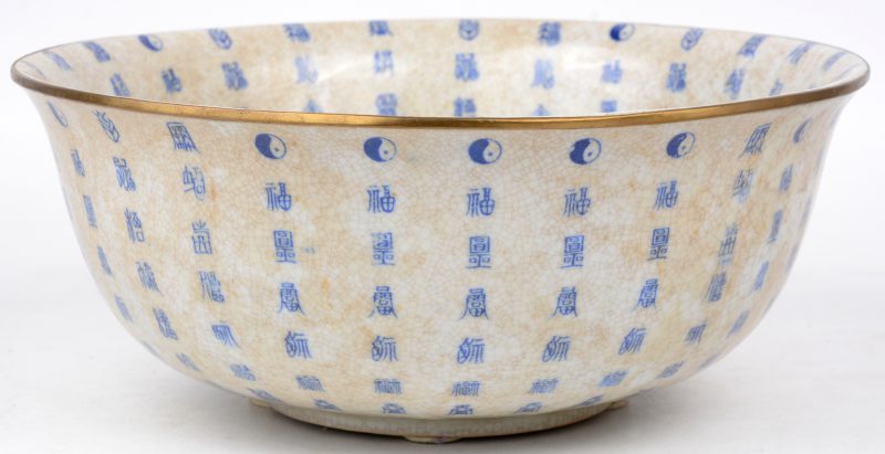 Een grote kom van Chinees porselein met een blauw decor van tekens en met messingen rand. Onderaan gemerkt.