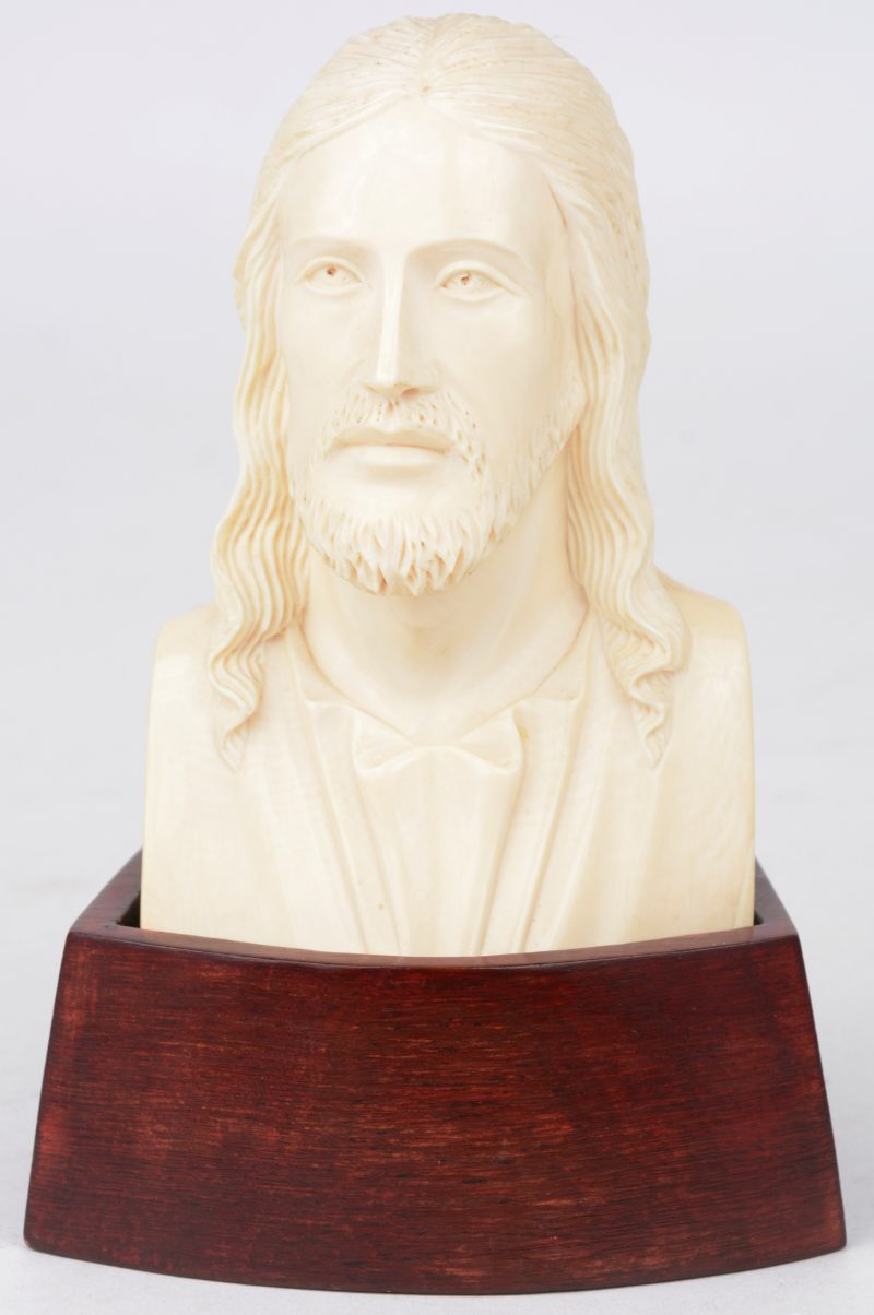 Een buste van Christus van gesculpteerd ivoor. Op houten sokkel.