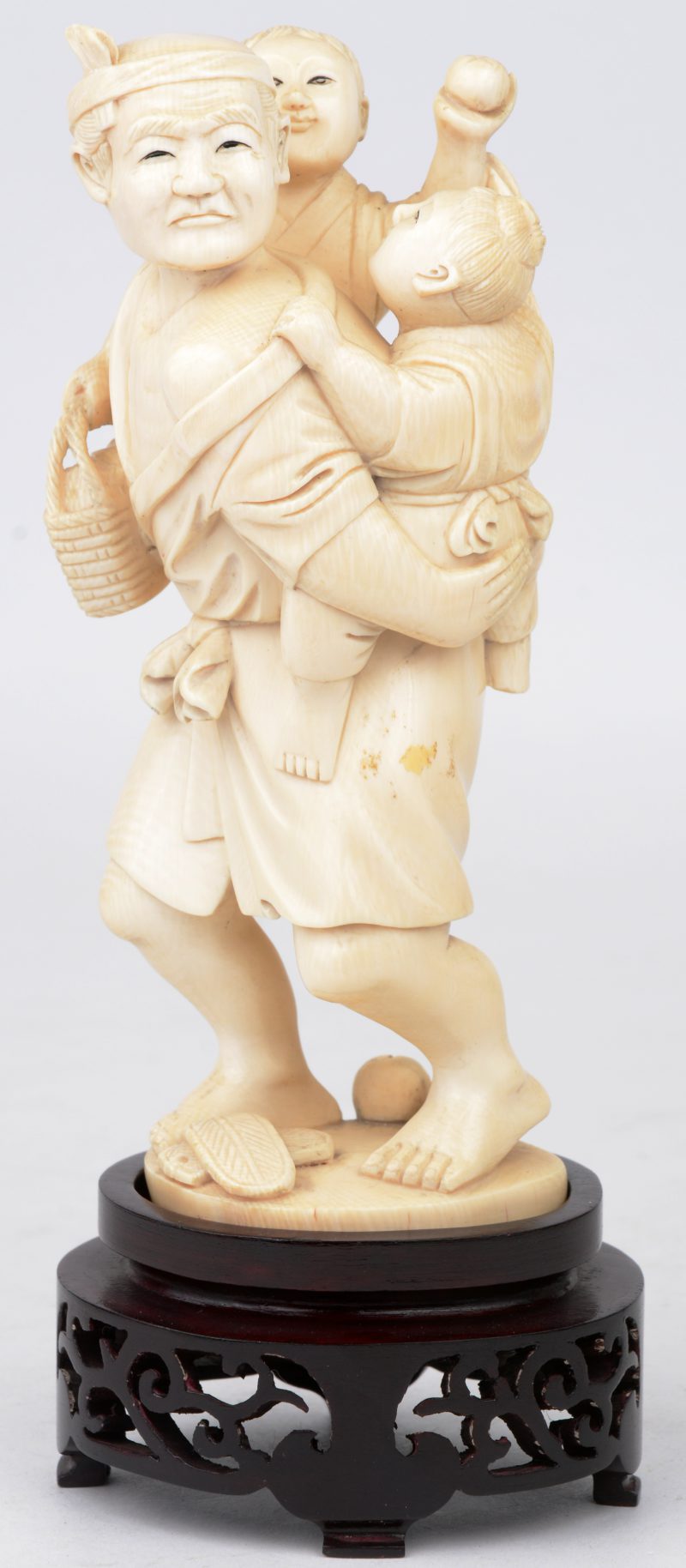 “Man met kinderen”. Een beeldje van gesculpteerd Chinees ivoor. Op houten voetstukje.