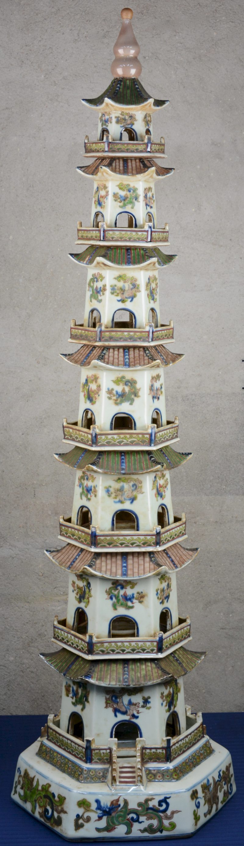 Een uit acht delen opgebouwde Chinese pagode van meerkleurig porselein met een decor van draken.