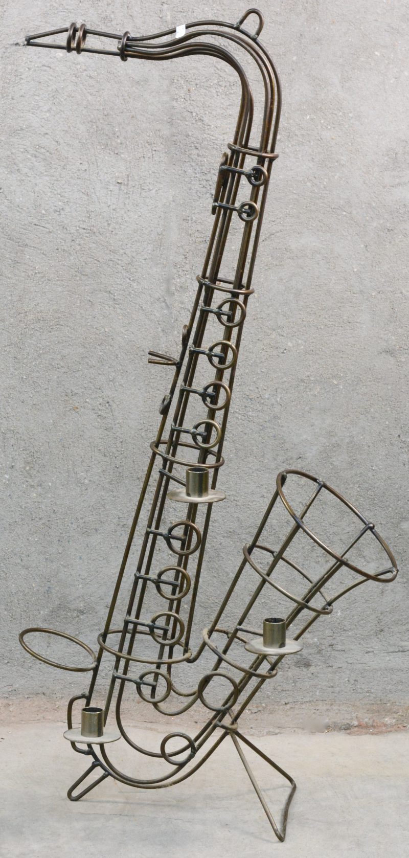 Kandelaar in de vorm van een saxofoon van smeedijzer.