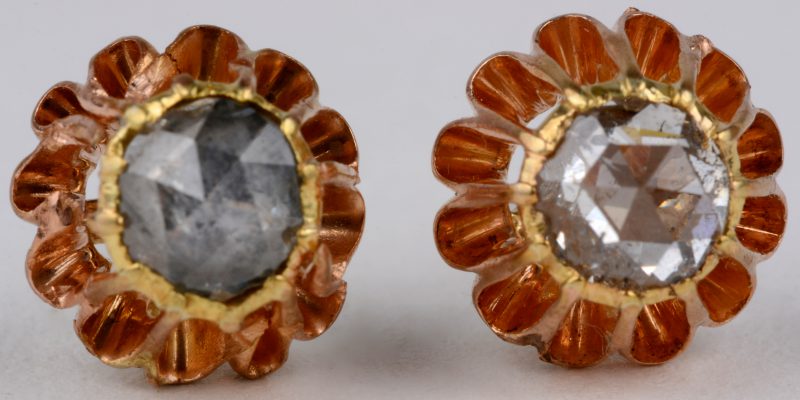 Een paar 18 karaats geel gouden oorbellen bezet met twee diamanten oude slijp met een gezamenlijk gewicht van ± 1 ct.