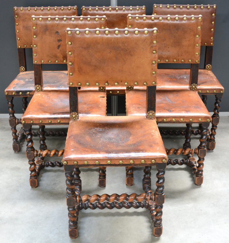 Een reeks van zes stoelen met getorste poten en lederen bekleding.