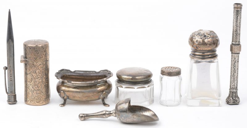 Een lot zilveren voorwerpjes, bestaande uit drie verschillende zoutstrooiertjes, een zoutvaatje met schepje, een parfumflesje en twee pennen. Engelse keuren.