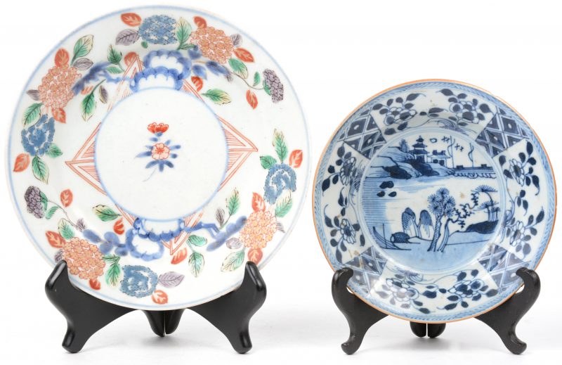Twee porseleinen bordjes, waarbij het kleine Chinees, met een blauw-wit landschapsdecor, het andere Japans, met een floraal decor. Het eerste met een haarscheur. Beide XIXe eeuw.