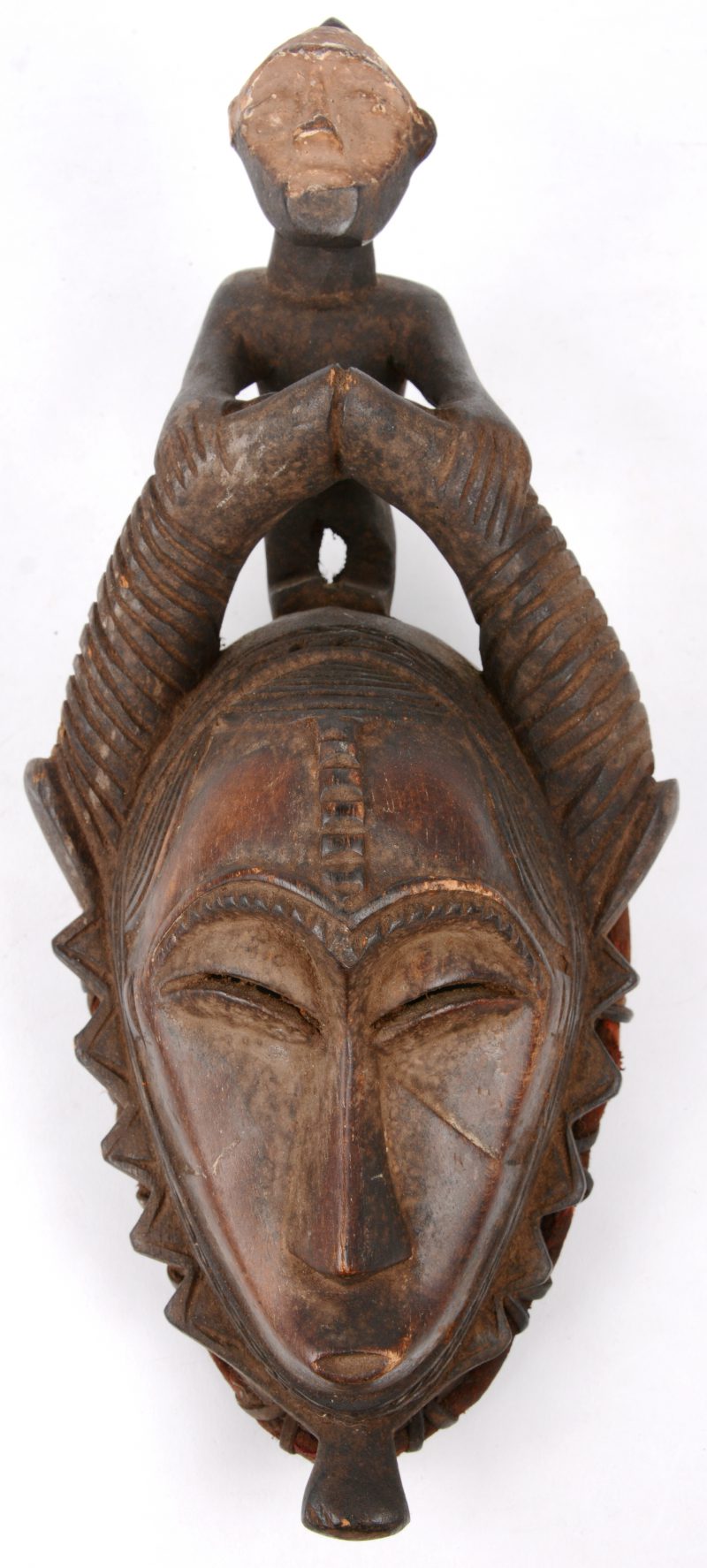Een klein Afrikaans houten maskertje, getooid met een mannetje.