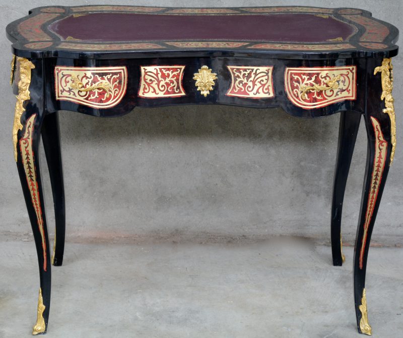 Een bureau van zwartgelakt hout met imitatieschildpad en verguld bronsbeslag in de stijl van Boulle.
