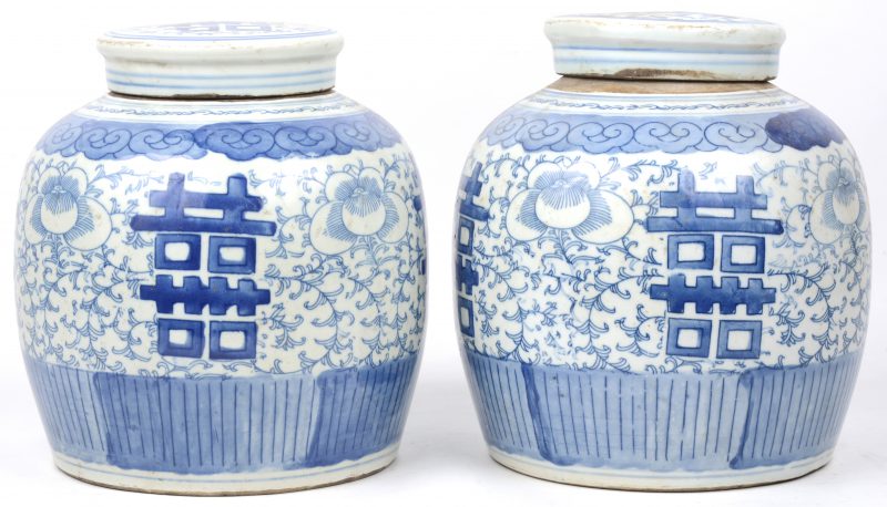 Een paar gemberpotten van blauw en wit Chinees porselein met eeuwig levenstekens in het decor.