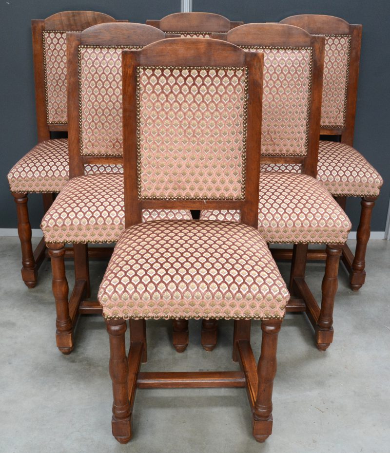 Een serie van zes sobere eikenhouten stoelen.