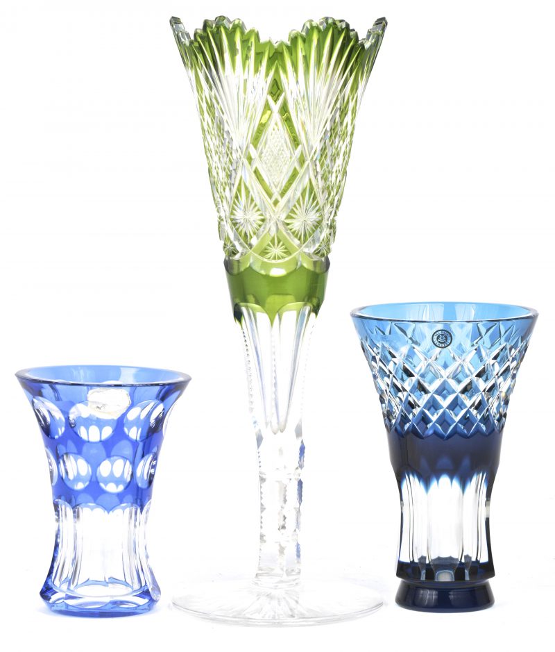 Drie geslepen kristallen vazen waarbij één groene op voet uit Bohemen en twee blauwe  van Val St. Lambert.
