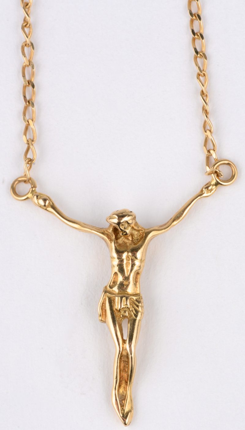 Een 18 karaats geel gouden ketting met hanger in de vorm van Christus.
