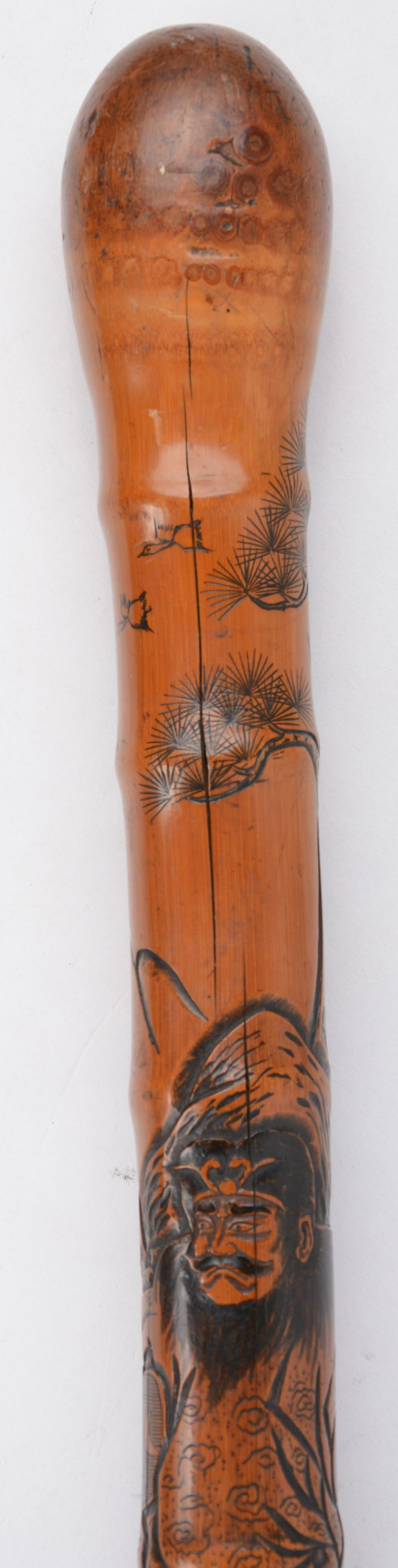 Een wandelstok van bamboe met een uitgestoken decor van krijgers. Onderaan een uitneembare degen met ivoren handvat.