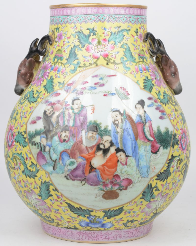 Een vaas van Chinees porselein met een famille-rosedecor van pioenen op gele fond en personages in cartouches. De handvatten in de vorm van hertenkoppen.