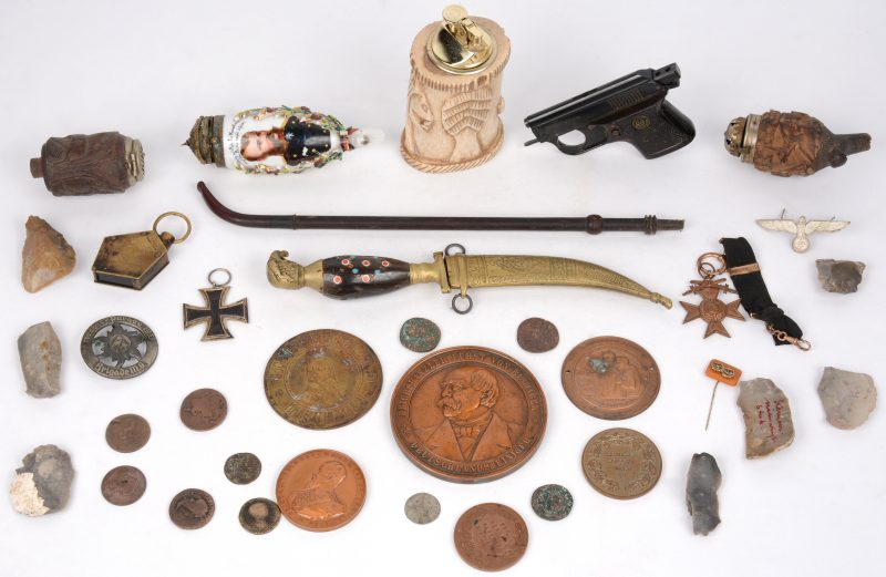 Een lot varia met Duitse militaire memorabilia, enkele oude munten, wat silex, een Arabische sierdolk en enkele pijpenkoppen.
