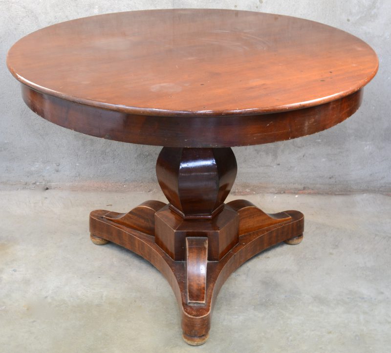 Een ronde tafel van mahoniehoutfineer op centrale voet. XIXe eeuw.