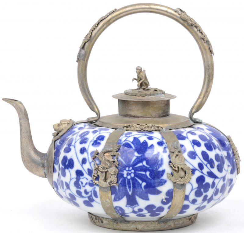Een pompoenvormig theepotje van blauw en wit Chinees porselein met verzilverd metalen monturen, versierd met draken en het deksel getooid met een aapje.