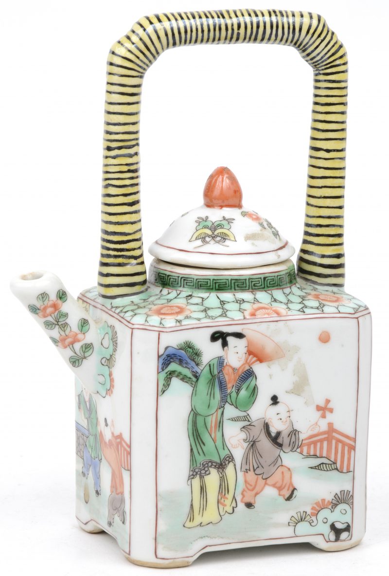 Een vierhoekig theepotje van Chinees porselein met een meerkleurig decor van personages in een landschap en met een geel handvat.
