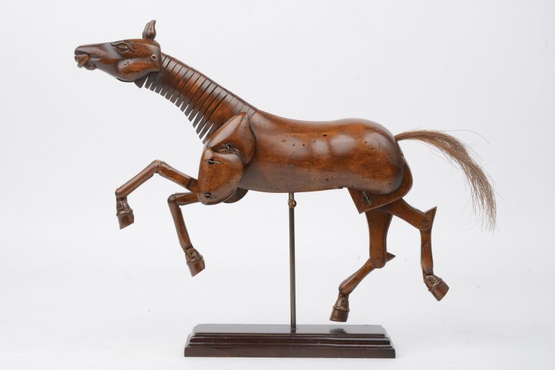 Een houten schildersmodel in de vorm van een paard.