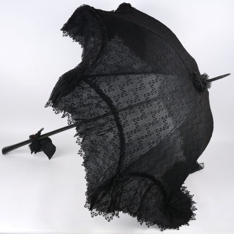 Een antieke parasol van zwarte Chantilly kant en borduursel. Omstreeks 1900.