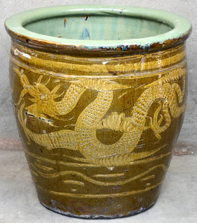 Een Chinese cachepot van meerkleurig aardewerk met een drakendecor.