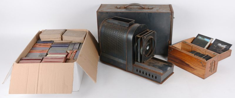 Een oude metalen projector met een uitgebreide projectie glazen diaplaten. Enkele manco’s.