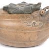 Een staande Guan-Yin van terracotta naar een voorbeeld uit de Tang en een pomoenvormig theepotje van aardewerk. Het tweede onderaan gesigneerd.