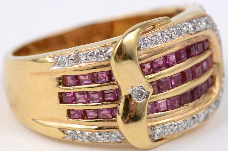 Een 18 karaats geel gouden ring bezet met diamanten met een gezamenlijk gewicht van ± 0,20 ct. en robijnen baguettes met een gezamenlijk gewicht van ± 1,30 ct.