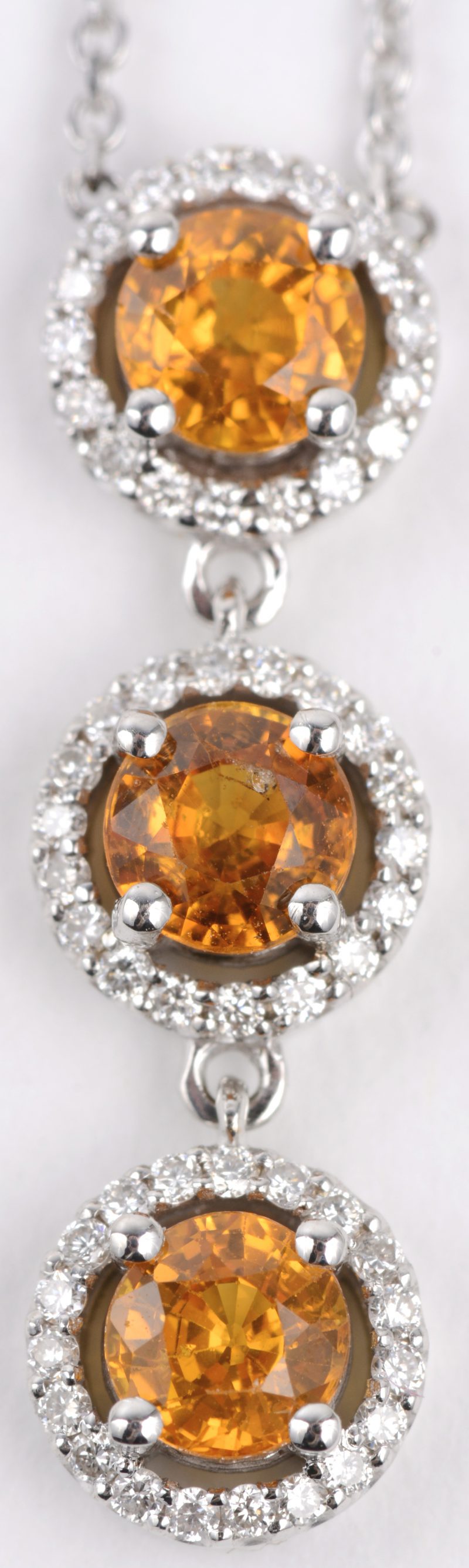 Een 18 karaats wit gouden ketting met hanger bezet met diamanten met een gezamenlijk gewicht van ± 0,45 ct. en drie gele saffieren met een gezamenlijk gewicht van ± 1.33 ct.