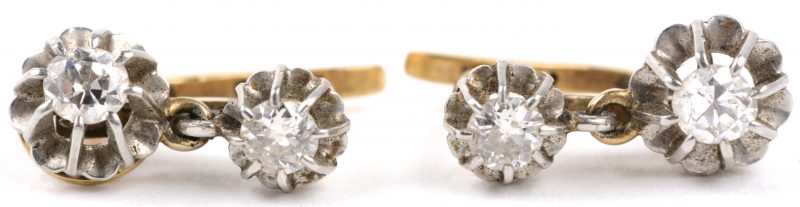 Een paar 18 karaats wit en geel gouden oorbellen bezet met diamanten met een gezamenlijk gewicht van ± 0,60 ct.