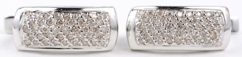 Een paar 14 karaats wit gouden oorbellen bezet met diamanten met een gezamenlijk gewicht van ± 0,80 ct.