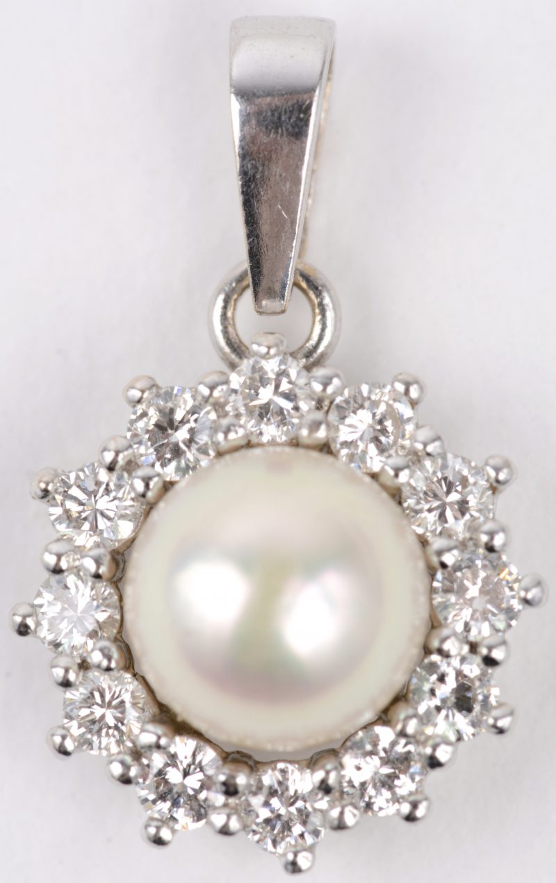 Een 18 karaats wit gouden hangertje bezet met diamanten met een gezamenlijk gewicht van ± 0,40 ct. en een parel.