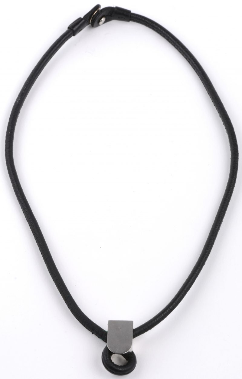 Een lederen halssnoer bezet met metalen versiering. In origineel etui met certificaat en stofhoes.