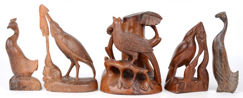 Een lot Aziatisch houtsnijwerk, bestaande uit vijf verschillende vogels, waarvan één met glazen oogjes.