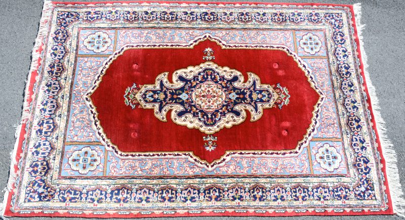 Een handgeknoopt Perzisch wollen tapijt met centraal medaillon.