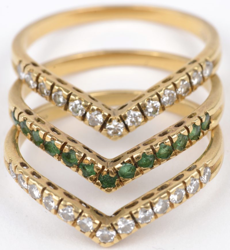 Drie 18 karaats geel gouden ring bezet met diamanten met een gezamenlijk gewicht van ± 0,54 ct. en smaragd met een gezamenlijk gewicht van ± 0,26 ct.