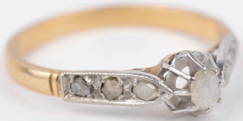 Een 18 karaats wit en geel gouden ring bezet met diamanten oude slijp met een gezamenlijk gewicht van ± 0,20 ct.