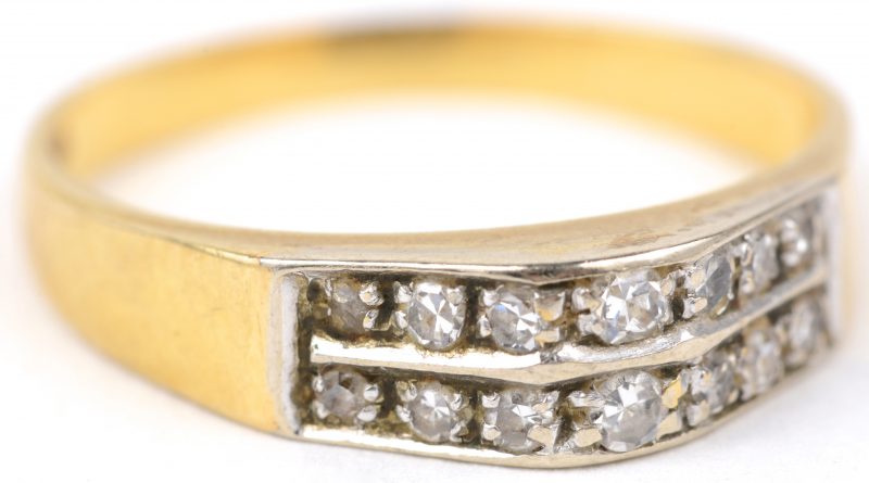 Een 18 karaats wit en geel gouden ring bezet met diamanten met een gezamenlijk gewicht van ± 0,30 ct.
