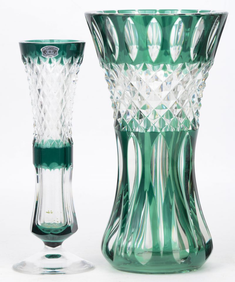 Een soliflore op voet en een vaas van geslepen kleurloos kristal met in de massa groen gekleurde motieven. Beide gemerkt onderaan.